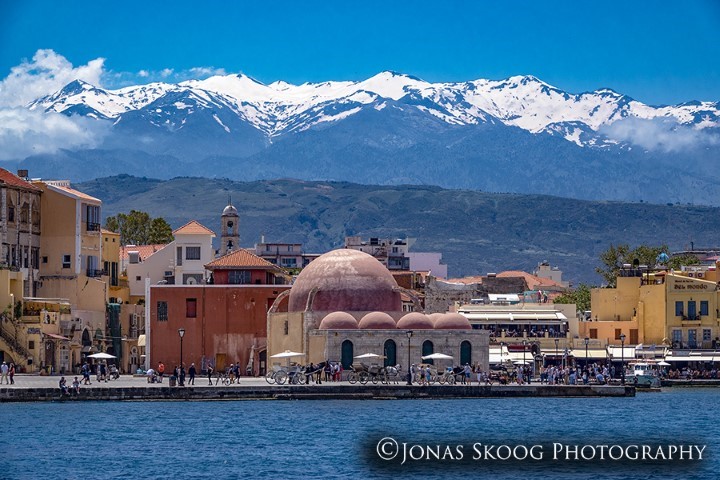 Exit45 Travels-Chania Old Town - Crete - Old Venetian Port with Snow Capped Mountains in the Background