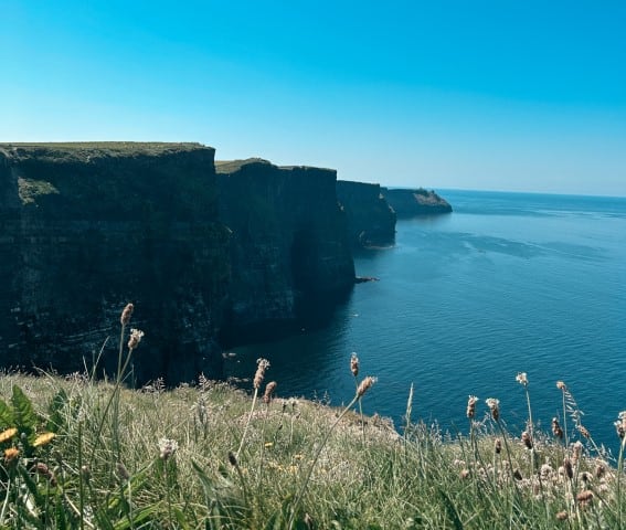 cliffs of moher in the distance overshadowing the ocean