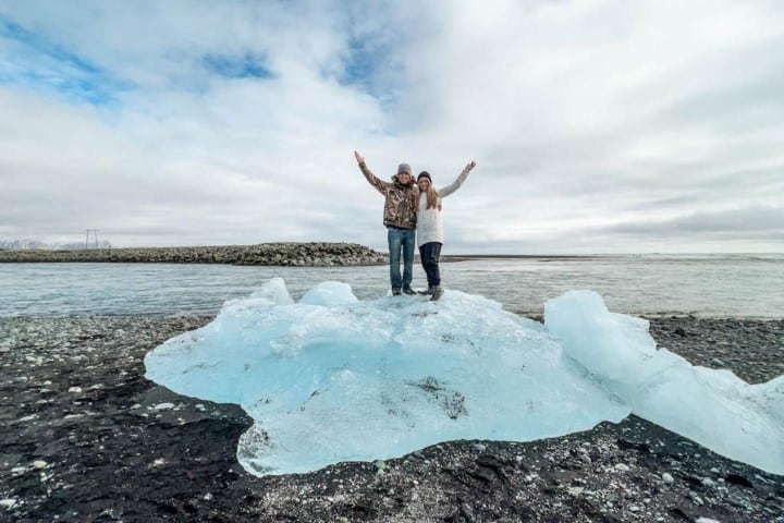 a couple standing on a glacier at Jokulsarlon Glacier Lagoon in iceland, one of the best countries to visit in march for the northern lights