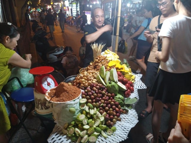 VENDOR SELLING FRUIT AT A LOCAL MARKET IN VIETNAM